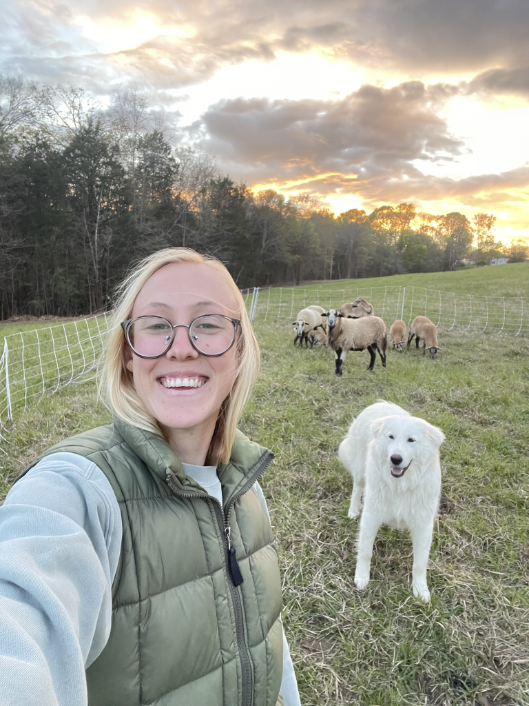 Hannah at the Garden, a global agriculture storyteller and first generation farmer with Maverick their livestock guardian dog